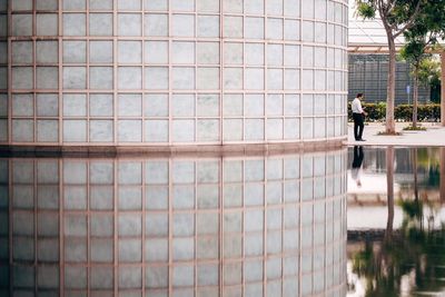People standing by glass building