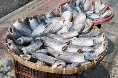 High angle view of dried fishes in container on crate for sale