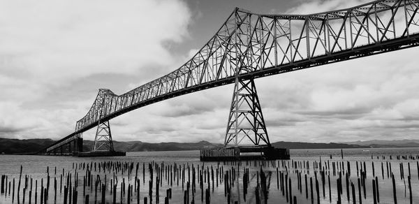 Low angle view of bridge against cloudy sky