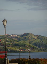 Street light by river against sky