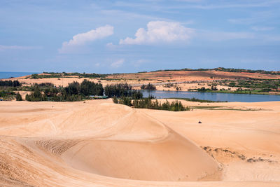 Scenic view of sand dunes against sky