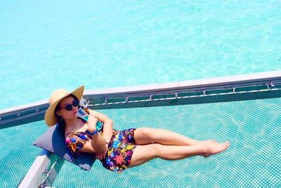 Portrait of young woman sitting at poolside