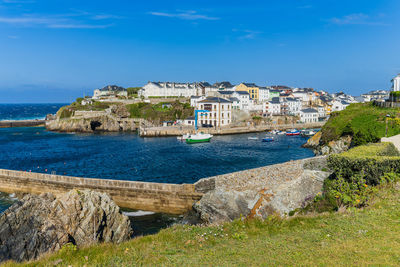 Buildings by sea against sky