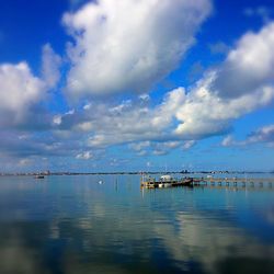 Pier on sea against cloudy sky