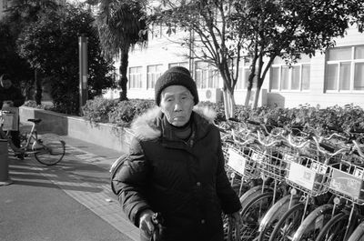 Portrait of young woman standing in city during winter