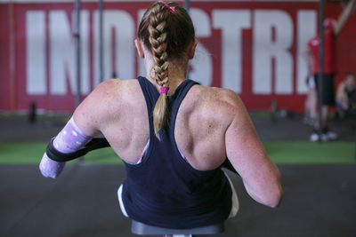 Rear view of female adaptive athlete exercising in gym