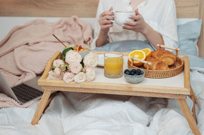 Romantic breakfast with coffee, waffles, orange juice and rose flowers.