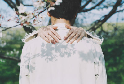 Rear view of woman standing by tree