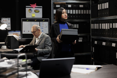 Rear view of man using laptop at office