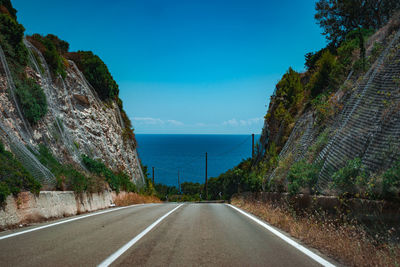 Road amidst trees against sky