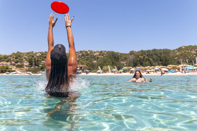 Two young girls playing with a plastic disc in the vacation and fun