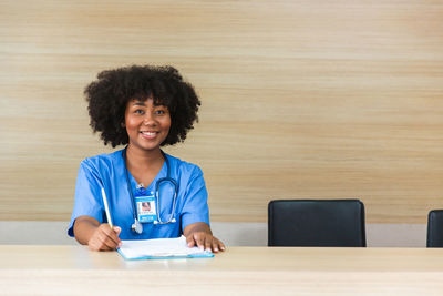 Portrait of young woman sitting on table