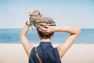 Woman standing on beach against sky