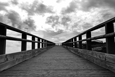 Footbridge over footpath against sky