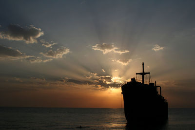 Silhouette sailboat on sea against sky during sunset