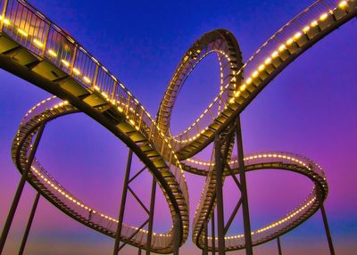 Low angle view of illuminated ferris wheel against sky at night