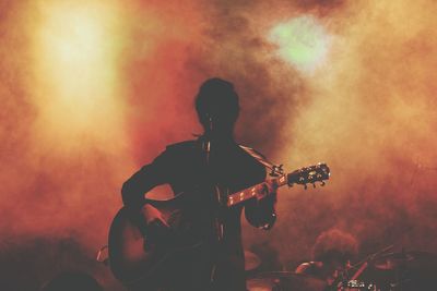 Rear view of man playing at music concert