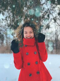 Portrait of a smiling woman standing in snow