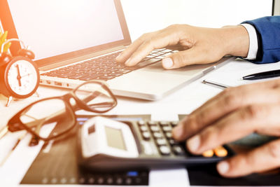 Midsection of person using laptop on table