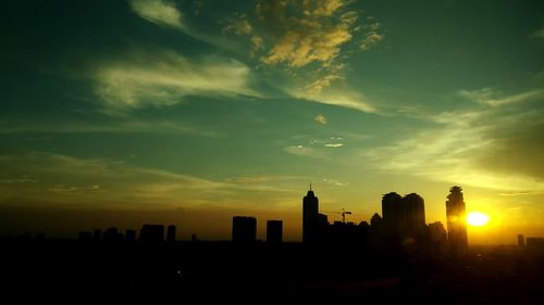 Silhouette buildings against sky during sunset