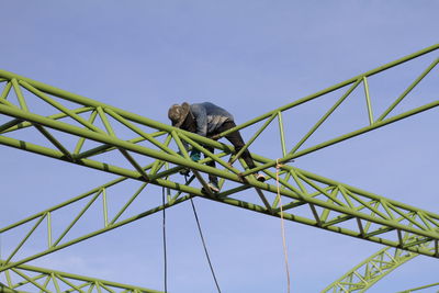 Low angle view of monkey on bridge against clear sky