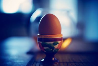 Close-up of brown egg in cup on table