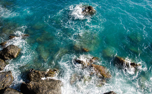 High angle view of waves splashing on rocks