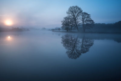 Scenic view of lake against sky during foggy weather