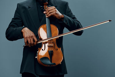 Midsection of man playing violin