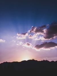 Low angle view of silhouette mountain against dramatic sky