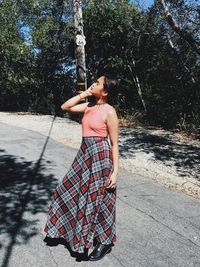 Woman standing on road during sunny day