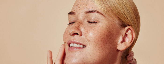 Close-up of young woman against wall