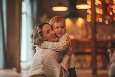 Portrait of happy family mom with small son in knitted beige sweaters