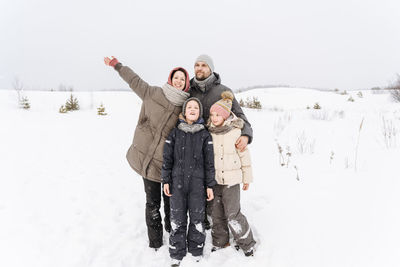 Family enjoying vacations together on snow covered landscape