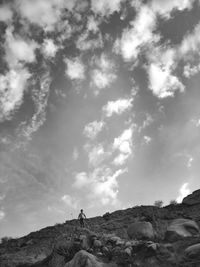 People standing on rock against sky