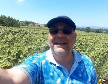 Portrait of man wearing sunglasses on field against sky