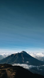 Scenic view of mountains against blue sky