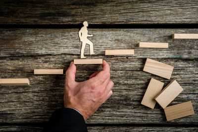 High angle view of hand holding toy on wooden table