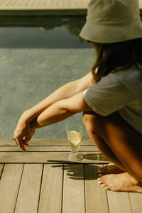 Side view of woman sitting on wooden floor