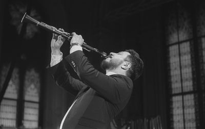 Man playing clarinet while standing at studio