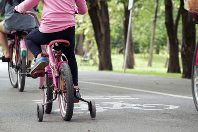 Low section of person riding bicycle on road