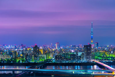 Illuminated buildings against sky at night