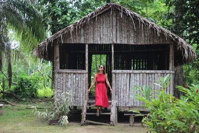 Side view of woman standing outside house