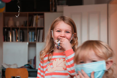 Portrait of cute girl wearing mask at home