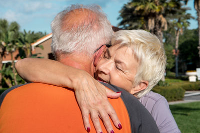 Rear view of senior couple embracing outdoors