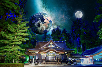 Digital composite image of illuminated stage against sky at night