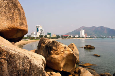 Scenic view of sea and buildings against clear sky