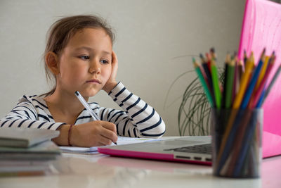 Girl using laptop while studying at home