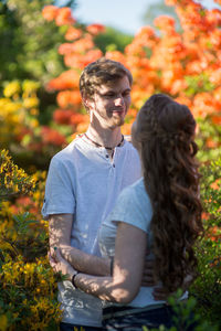 Couple standing against flowers at park