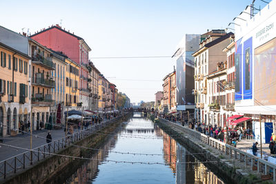 Canal amidst buildings against sky in city